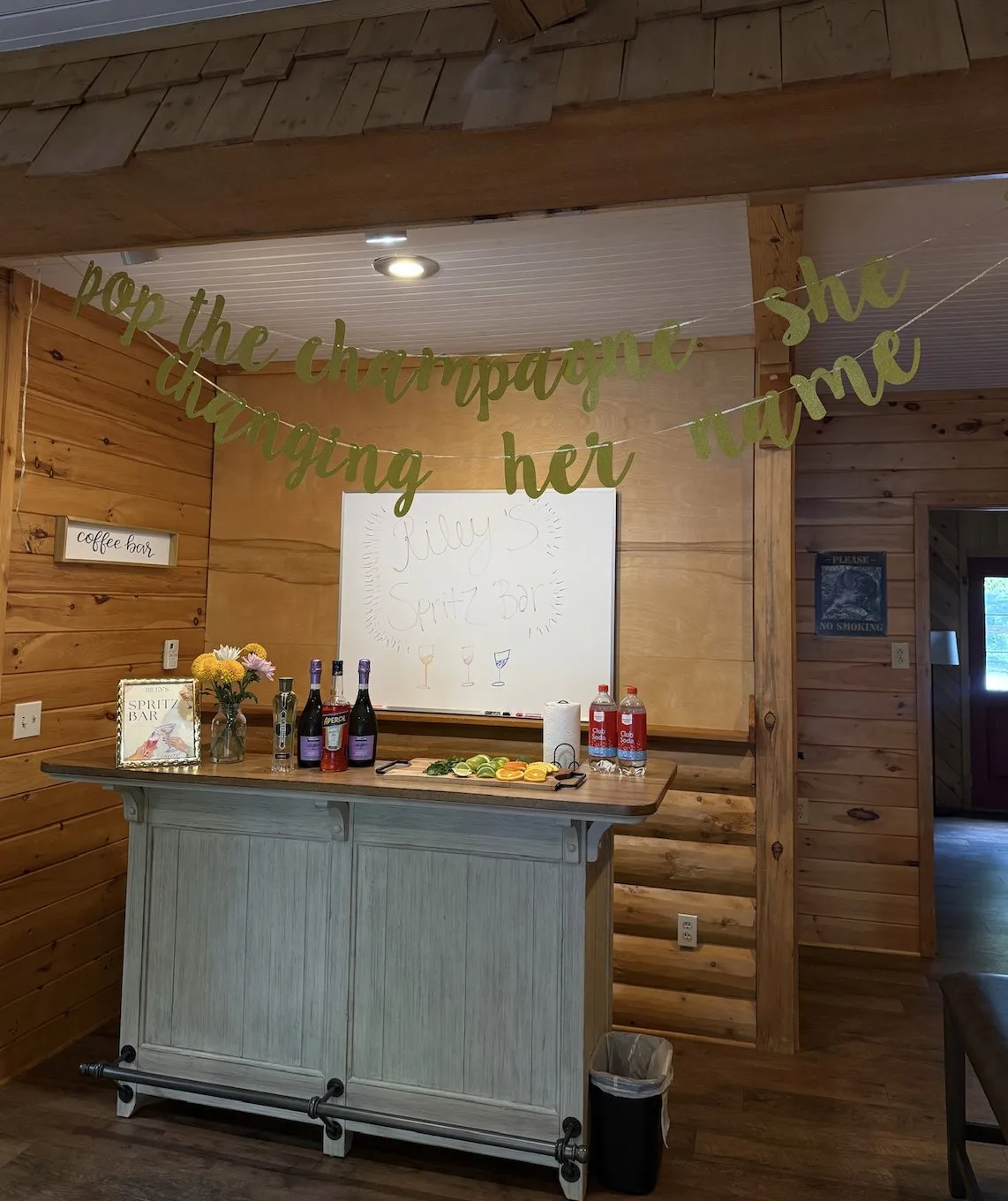 A spritz bar with Aperol, prosecco and sliced citrus under a banner